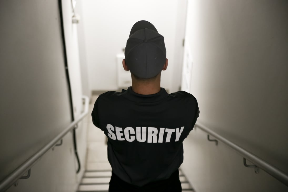 Security guard patrolling on stairs inside commercial building